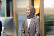 © NVB Stocker - Portrait of muslim woman receptionist at desk in lobby.  Asian business man standing at reception desk and talking to muslim woman receptionist.