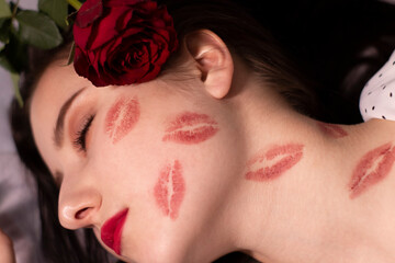 Wall Mural - sexy brunette woman with kisses, lipstick marks on her face and neck, with red rose. girlfriend, date, relashionship. lesbian gay. lgbt