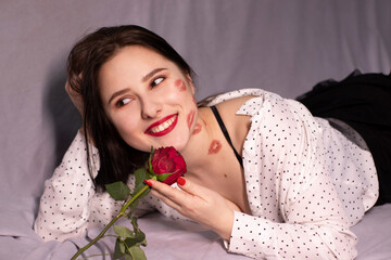 Wall Mural - sexy brunette woman with kisses, lipstick marks on her face and neck, with red rose. girlfriend, date, relashionship. lesbian gay. lgbt