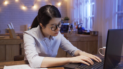 Wall Mural - Tired young female office worker fell asleep while sitting in front of laptop computer and working on promising project with blurred background of home kitchen. exhausted employee sleeping evening