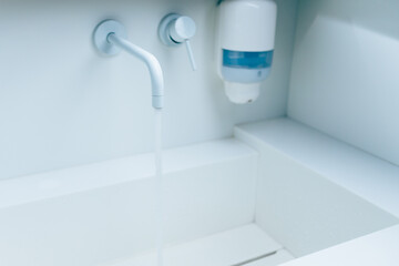 Wall Mural - wash-bowl with flowing water from faucet in a hospital