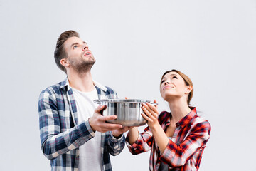 Canvas Print - young couple looking up while holding pot under leaking ceiling