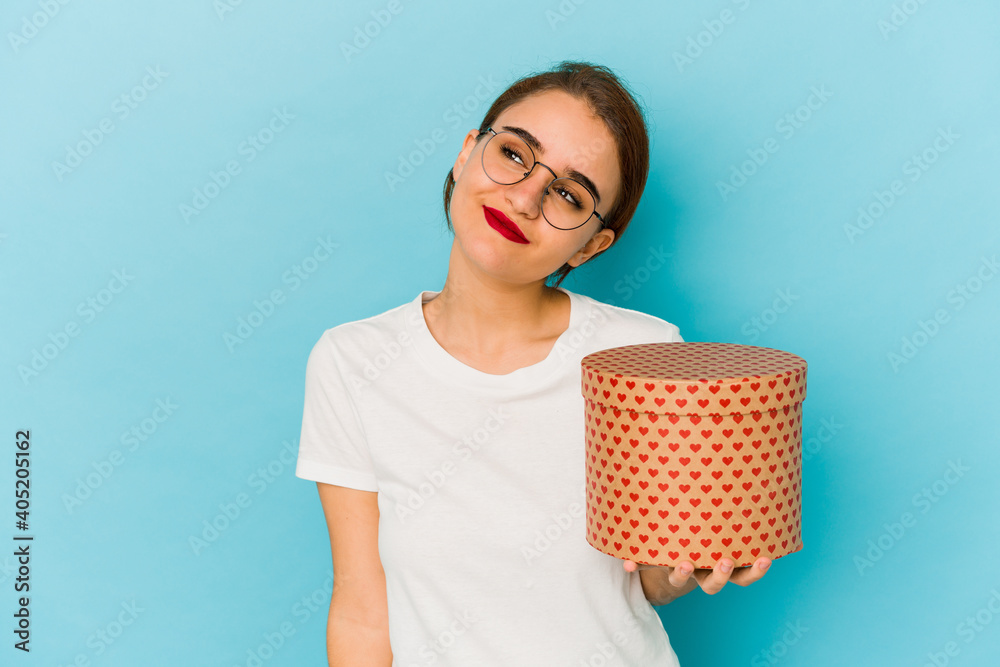 Young skinny arab girl holding a valentines day box dreaming of ...