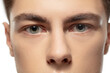 Eyes calm. Close up face of young man on white studio background. Caucasian attractive male model. Concept of fashion and beauty, self-care, body and skin care. Handsome boy with well-kept skin.