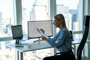 Fototapete - Cheerful businesswoman working at desk with gadgets in modern office