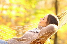 Woman Resting Lying On Hammock In Autumnal Forest