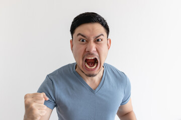 Wall Mural - Angry and mad face of Asian man in blue t-shirt on isolated background.