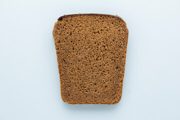 Single slice of brown rye bread on blue background. Top view.