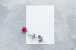 Valentines day, womens day, and other holidays festive background. on grey stone background sheet of paper and metalic rose. top view, flatly, copy space.