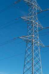 Power pole for electricity transmission and distribution in front of blue sky