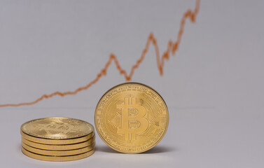 single bitcoin stands next to a stack of bitcoins with a stock market chart in the background