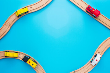 Baby kid toys background. Toy train and wooden rails on blue background. Top view