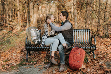 Young Couple Sitting Together On Bench During Autumn Hike