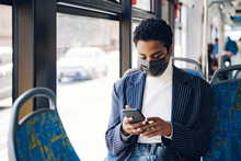 Young Businesswoman Using Mobile Phone In Bus During COVID-19