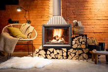 Cozy Fireplace With Firewood In The Loft Style Home Interior With Brick Wall Background, Burning Fire In The Fireplace, House Coziness In Winter