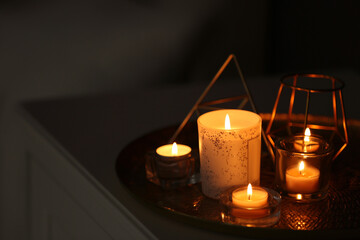 Beautiful burning candles and decor on table at home. Space for text