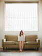 © Jessica Peterson/Tetra Images - Young woman sitting on sofa with laptop