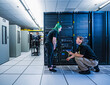 © Erik Isakson - Co-workers talking in data center server room