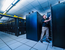 Employee Working On Server Rack In Data Center