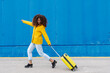 © COROIMAGE/Westend61 - Carefree woman running with luggage on footpath