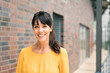 © Joseffson/Westend61 - Smiling female entrepreneur by wall in corridor