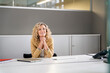 © peter scholl/Westend61 - Smiling female professional with hands clasped day dreaming at desk in office