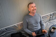 © Floco Images/Westend61 - Happy businessman with digital tablet looking up while sitting at modern cafe
