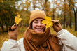 © alev/Westend61 - Happy young woman covering eye with autumn leaf in public park