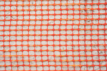 Texture Orange Fence Construction Mesh Close-up On A Gray Background.