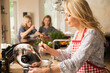 © Connect Images - Mother preparing food with daughters in background