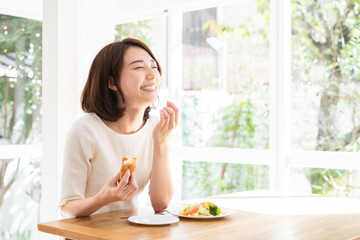 サラダとパンを食べる女性