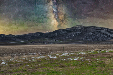 Poster - Beautiful shot of greenery covered hills with the Milky Way galaxy in a starry sky