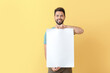 © Pixel-Shot - Young man with blank paper sheet on color background