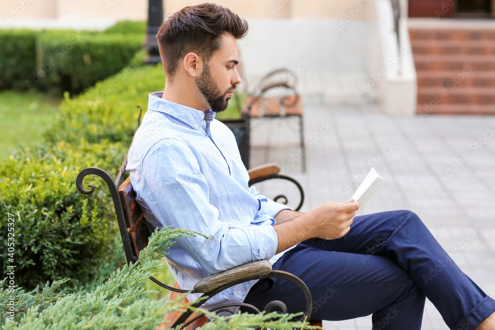 Young man with blank magazine in park