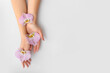 Female hands with beautiful flowers on light background