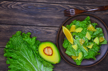 fresh summer homemade salad of vegetables and fruits, orange, lettuce, avocado and sesame seeds, healthy food, organic, vegetarian eco health and immunity products