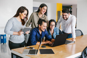 Wall Mural - Group of latin business people working together as a teamwork while sitting at the office desk in a creative office in Mexico city