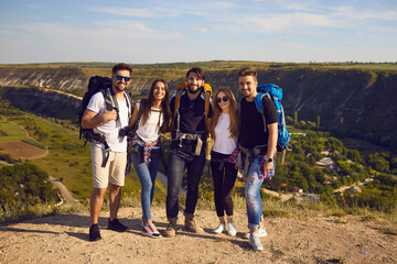 Wall Mural - portrait of a happy and joyful group of hikers on a background of mountain countryside.