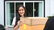 © Prathankarnpap - Happy young woman receiving package box from delivery man.