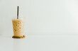 Iced coffee in a plastic cup on a wooden table at the cafe. Cold espresso in the coffee shop with copy space. Beverage glass frozen in the restaurant. Food sales busy interior decoration vintage.