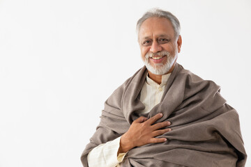 AN OLD MAN WEARING SHAWL HAPPILY SMILING AT CAMERA	