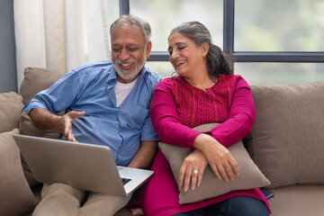 A HAPPY COUPLE SPENDING TIME TOGETHER WHILE USING LAPTOP	