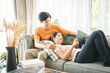 © Kris Tan - Happiness young family couple using mobile tablet for relaxing time at home.