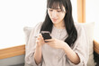 © maru54 - 自宅でスマートフォンを操作する女性