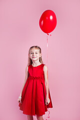 Wall Mural - Valentines day. Little girl in red dress with heart shape air balloon on pink background