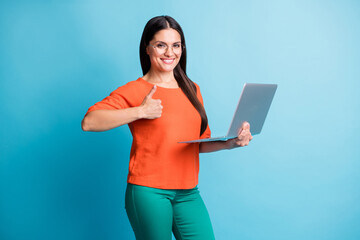 Sticker - Photo of charming positive person hand hold laptop show thumb up eyewear isolated on blue color background