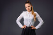 © Viorel - Serious young business woman in white shirt posing on gray background with blank space.