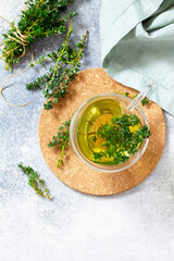 Wall Mural - Therapeutic herbal tea. Hot cup of thyme tea on a light stone countertop. Top view flat lay. Free space for your text.