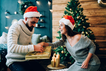 Wall Mural - Couple helping open Christmas presents