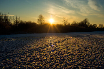 bright yellow beautiful sunrise over a frozen lake